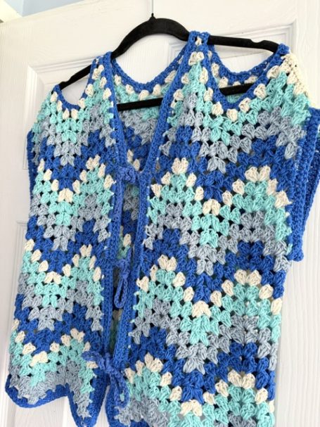 Cold Shoulder Crochet Waistcoat Crochet vest with a zigzag pattern in blue, turquoise, and cream colours.